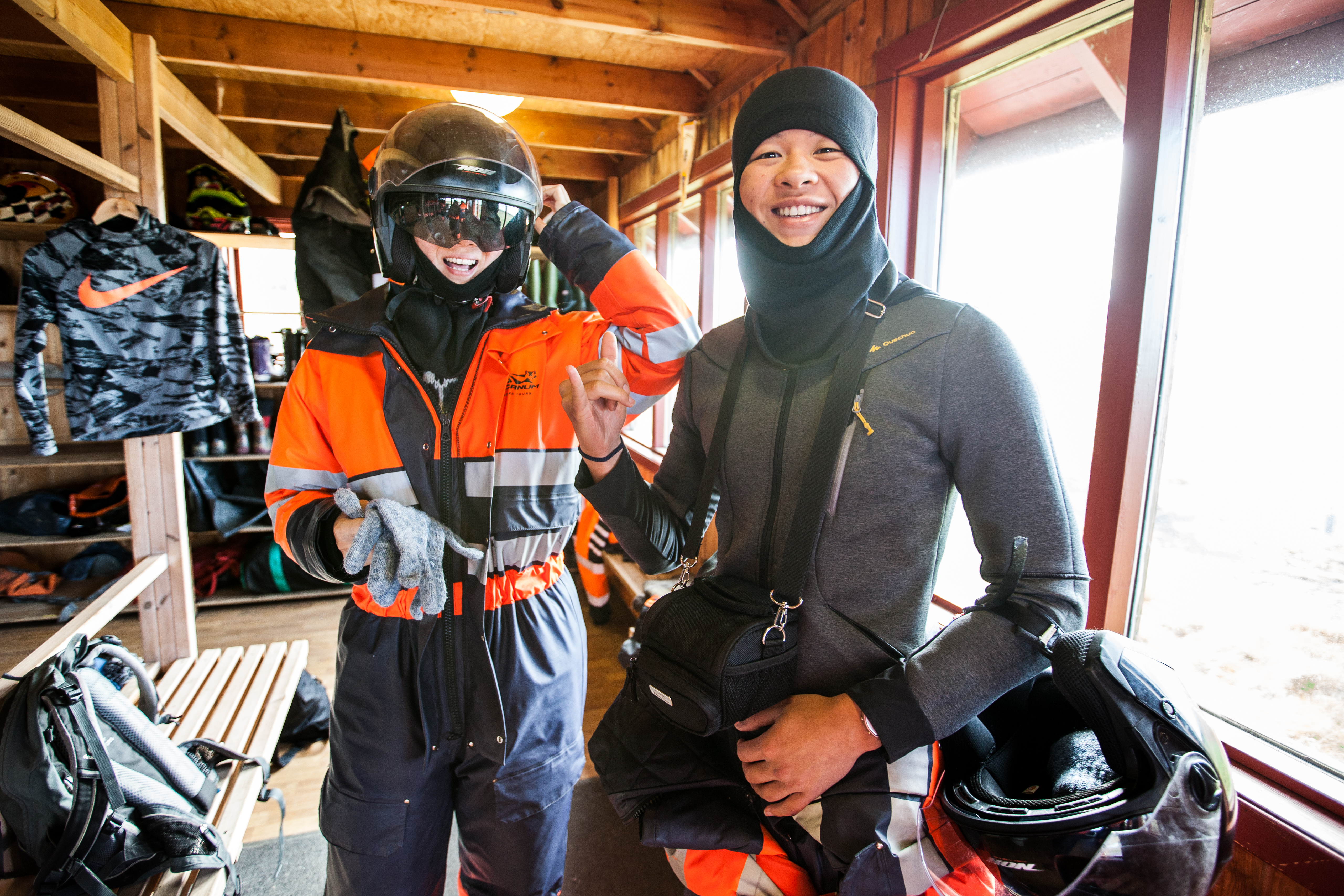 Two people getting ready for a thrilling snowmobile ride